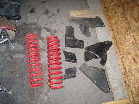 1995 Ford Bronco - Various suspension components, including coil springs and mounting brackets, are laid out on a workshop floor.