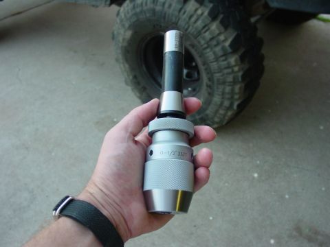 1994 Ford Bronco - Drill chuck with 0-1/2" 33JT capacity held in hand, with a vehicle tire in the background.
