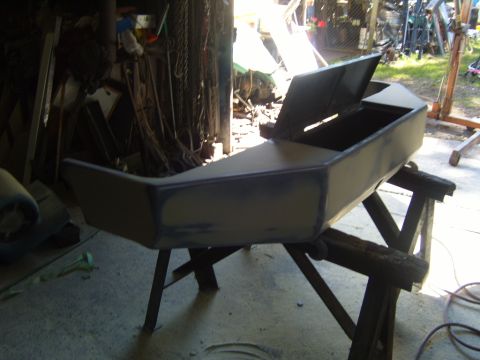 1989 Ford Bronco - A car bumper is being worked on in a garage, with tools and equipment visible in the background.
