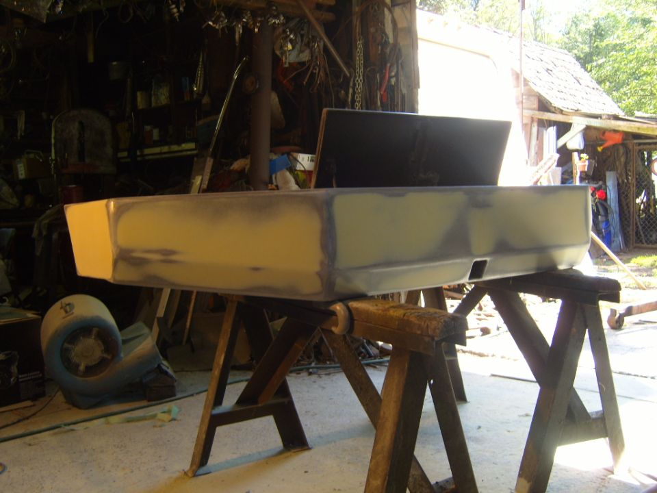 Car bumper on sawhorses, covered in primer and body filler