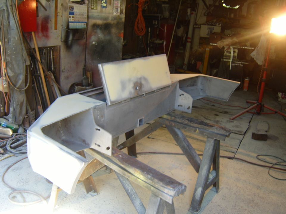 Ford Bronco front bumper, unpainted, on sawhorses in a garage