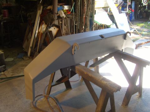 1989 Ford Bronco - A vehicle bumper is being prepped for paint in a workshop setting.