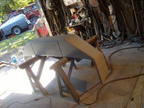1989 Ford Bronco - 1989 Ford Bronco front bumper undergoing bodywork and prep for paint in a garage.