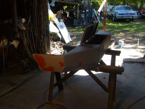 1989 Ford Bronco - A car bumper is being prepped for paint in a cluttered garage, with other vehicles visible outside.