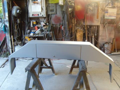 1989 Ford Bronco - Front bumper being prepped for paint in a workshop setting.