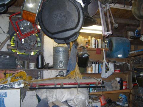 1989 Ford Bronco - Garage interior filled with various automotive parts, tools, and supplies on shelves.