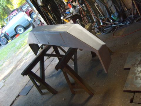 1989 Ford Bronco - A custom metal bumper is being worked on in a garage, with other vehicles and tools in the background.