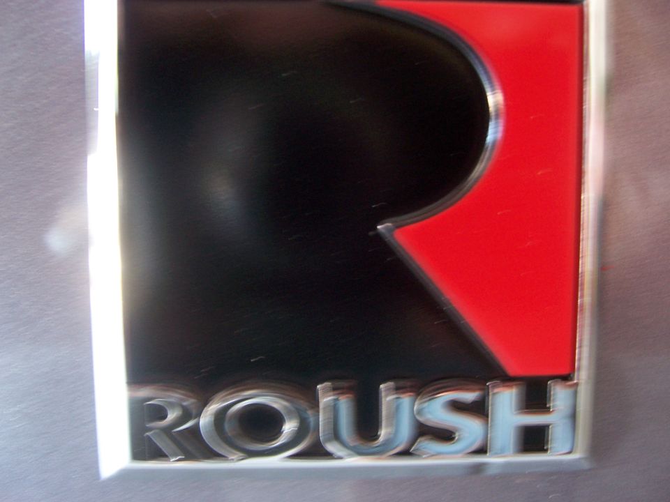 Close-up of a silver and red Roush badge with chrome lettering