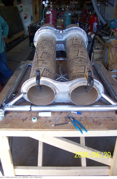 1977 Ford F-150 - Custom exhaust pipes are clamped in place on a workbench, ready for installation.