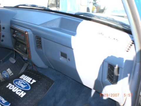 1991 Ford Bronco - The dashboard and floor mats of a Ford vehicle are visible in this interior shot.