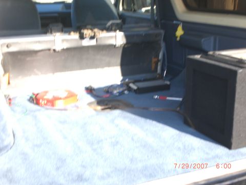1991 Ford Bronco - Vehicle interior cargo area with a subwoofer box and other items on the floor.