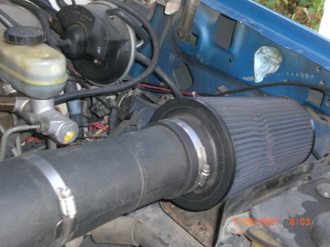 1991 Ford Bronco - Aftermarket air intake system installed in the engine bay, with visible brake components.