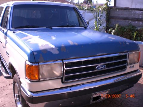 1991 Ford Bronco - This 1991 Ford Bronco is shown in a front three-quarter view, displaying its two-tone blue and white paint scheme.