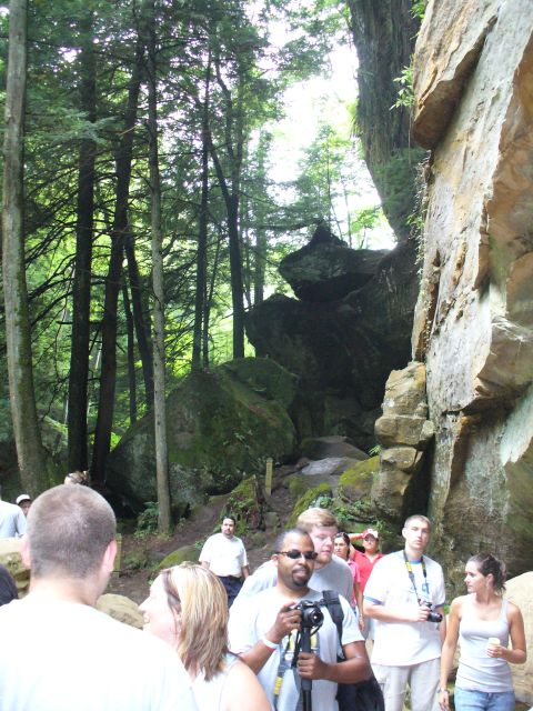 1991 Ford Probe - People explore a wooded area with towering rocks and trees, a path winding through the natural landscape.