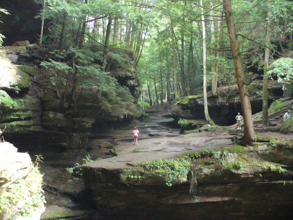 Rocky canyon with trees and a few people walking