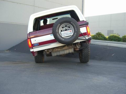 1991 Ford Bronco - This 1991 Ford Bronco is seen from the rear, a two-tone maroon and white paint scheme and a spare tire on the tailgate.