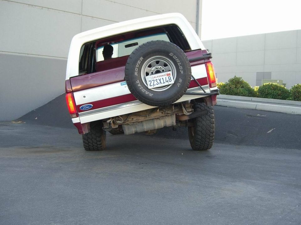 Rear view of a maroon and white 1991 Ford Bronco with a spare tire mounted externally