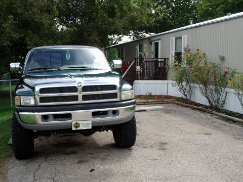 1996 Ford Bronco - Front view of a green Dodge Ram pickup truck parked in a driveway.