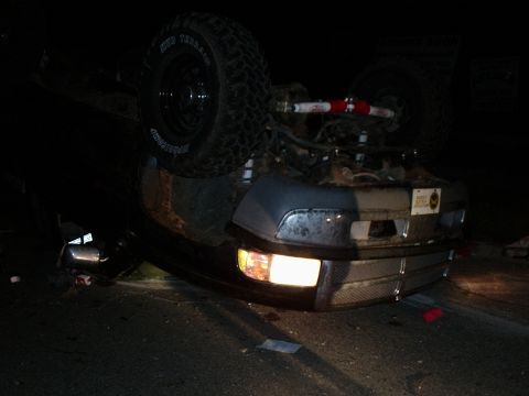 1996 Ford Bronco - This 1996 Ford Bronco is overturned on its side, with its front end and headlights visible.