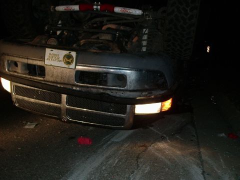 1996 Ford Bronco - Vehicle overturned on its side, front end visible with headlights illuminated and a military police plate.