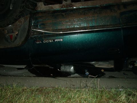 1996 Ford Bronco - The side of a green Dodge Ram 1500 V8 is visible, with damage to the undercarriage.