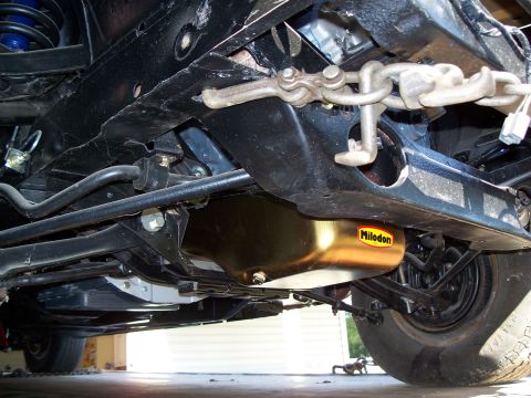 1971 Ford Ranchero - The underside of a vehicle shows a gold Milodon oil pan and suspension components.