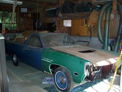 1971 Ford Ranchero - A two-tone Ford Ranchero sits in a cluttered garage with its hood off and front end partially dismantled.