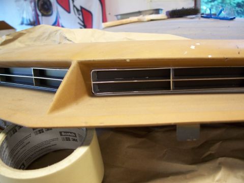 1971 Ford Ranchero - Close-up of a yellow hood scoop with horizontal vents and chrome trim, with masking tape in the foreground.