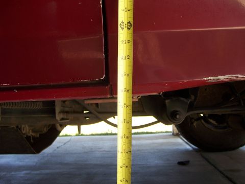 1991 Ford Bronco - A tape measure is used to document the height of a vehicle's suspension components.