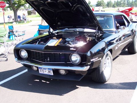 1972 Ford Ranchero - Front view of a black 1969 Chevrolet Camaro SS at a car show, hood up to display the engine.