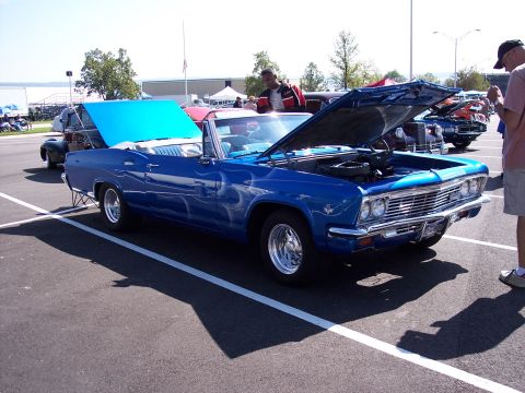1972 Ford Ranchero - A blue 1965 convertible with flame decals and its hood open is displayed at an outdoor car show.