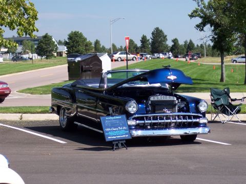 1972 Ford Ranchero - A blue 1956 Chevrolet Bel Air convertible is displayed with its hood open at an outdoor car show.