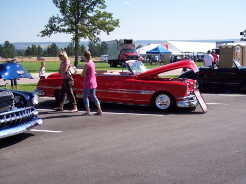 1972 Ford Ranchero - A classic red convertible is displayed with its hood up at an outdoor event.
