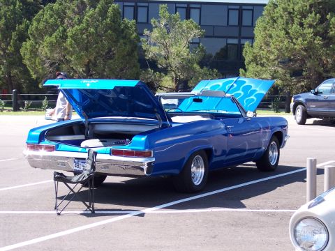 1972 Ford Ranchero - A blue convertible with custom flame paint sits in a parking lot with its hood and trunk open.