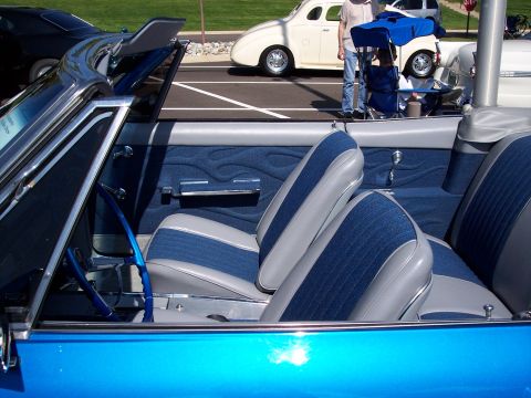 1972 Ford Ranchero - Interior view of a blue convertible with custom upholstery and a blue steering wheel, parked at an outdoor event.