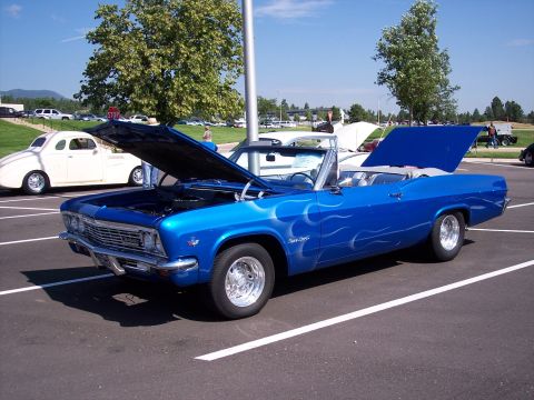 1972 Ford Ranchero - Blue 1965 Chevrolet Impala convertible with flame decals, hoods open, parked at an outdoor event.