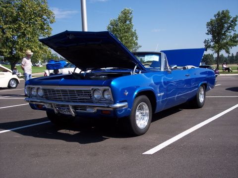 1972 Ford Ranchero - A bright blue convertible with its hood open sits in a parking lot on a sunny day.