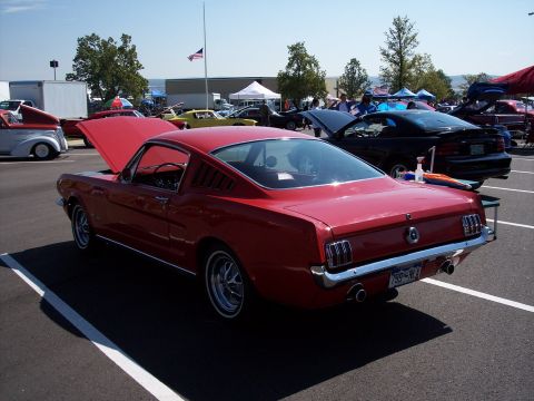 1972 Ford Ranchero - A red classic coupe is parked at an outdoor event, with its hood open.