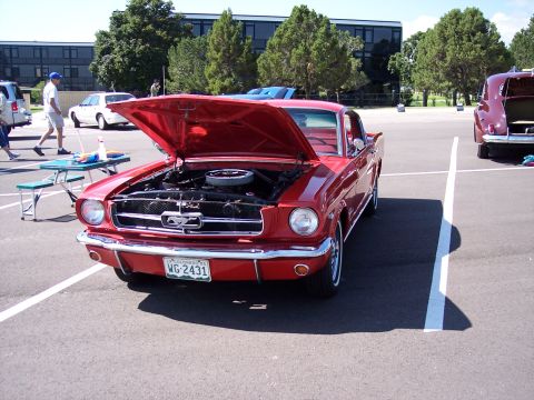 1972 Ford Ranchero - A red 1965 Ford Mustang is parked with its hood open, showing the engine.