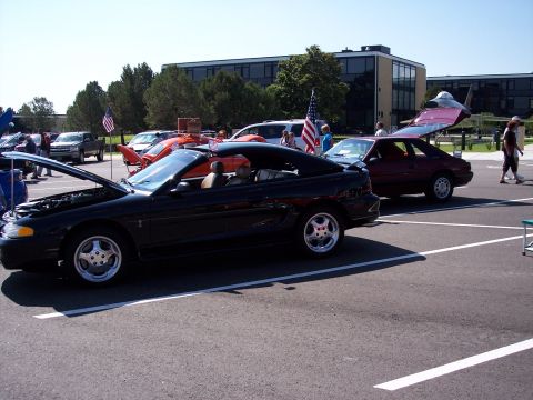 1972 Ford Ranchero - A black convertible is displayed with its hood open, parked at an outdoor event.