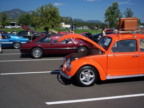1972 Ford Ranchero - An orange Volkswagen Beetle is parked at a car show with its hood open.