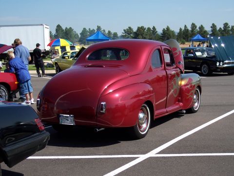 1972 Ford Ranchero - A classic red coupe with flame decals is parked at an outdoor event.