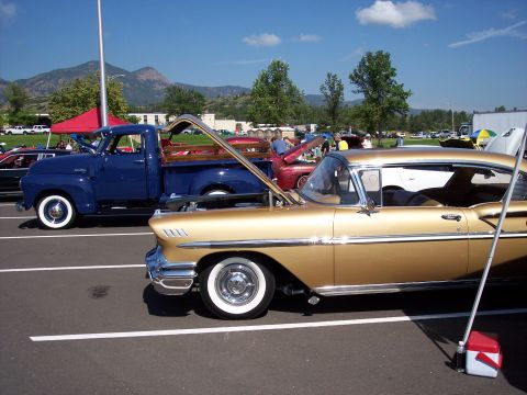 1972 Ford Ranchero - Two classic vehicles, a gold coupe and a blue pickup, are displayed at an outdoor event.