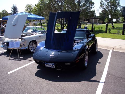 1972 Ford Ranchero - A black Chevrolet Corvette is parked next to a white convertible, both with hoods open.