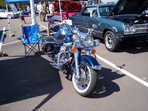 1972 Ford Ranchero - A blue motorcycle and a teal classic car are parked side-by-side at an outdoor event.