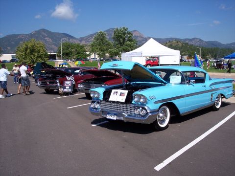 1972 Ford Ranchero - A light blue 1958 Chevrolet Impala coupe is displayed with its hood open at an outdoor car show.