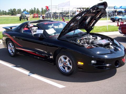 1972 Ford Ranchero - A black Pontiac Firebird Trans Am convertible is displayed with its hood open, the engine bay.