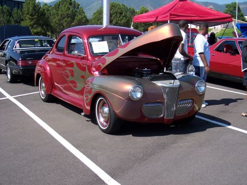 1972 Ford Ranchero - A custom hot rod coupe with flame graphics is displayed with its hood open.