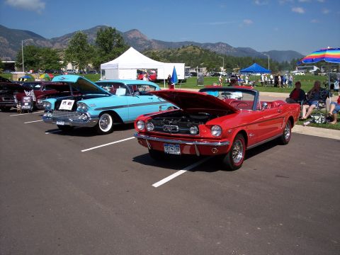 1972 Ford Ranchero - Two classic cars, a red convertible and a blue sedan, are displayed with their hoods open at a sunny outdoor event.