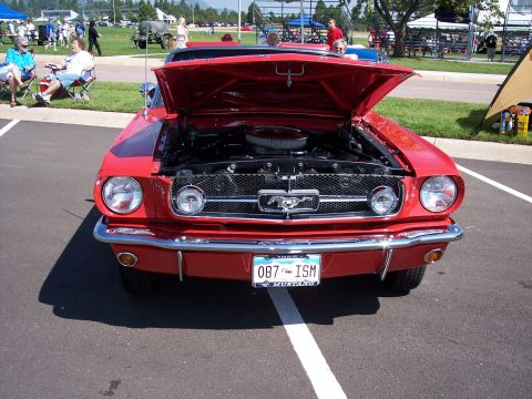 1972 Ford Ranchero - A red 1965 Ford Mustang is parked with its hood open, displaying the engine and grille.